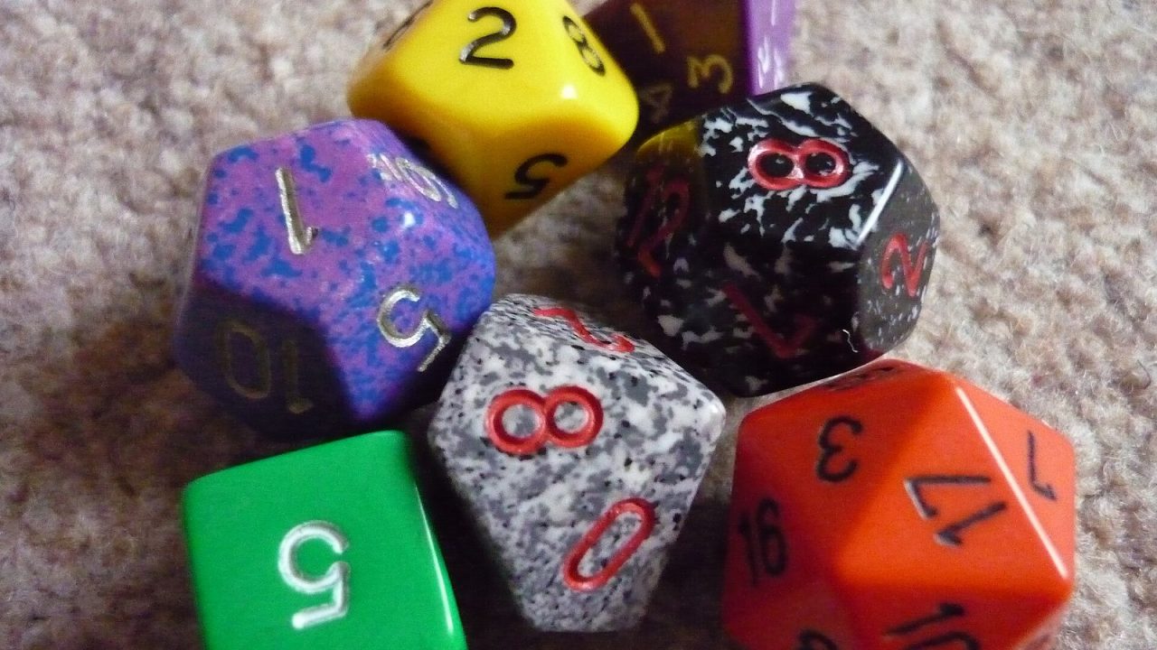 Colorful polyhedral role-playing dice including a twenty-sided die on a table