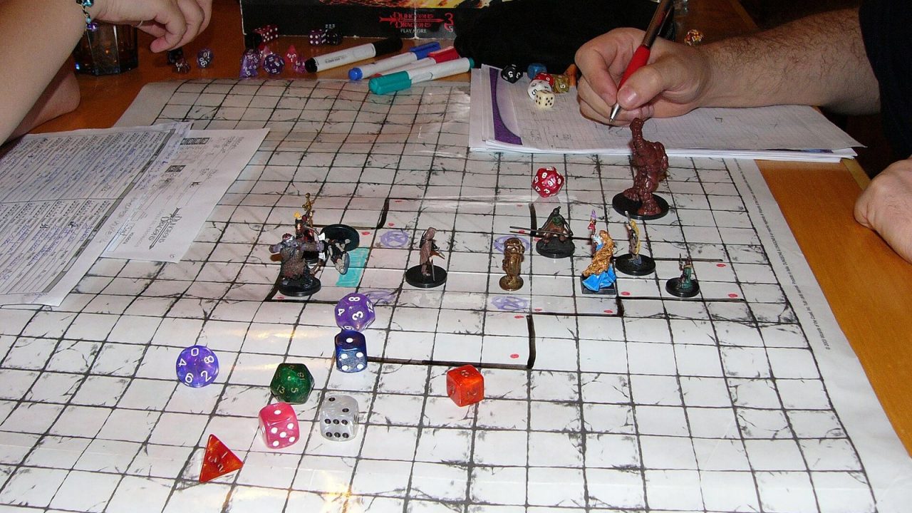 Tabletop Dungeons & Dragons session with a hand-drawn dungeon map, dice and miniatures